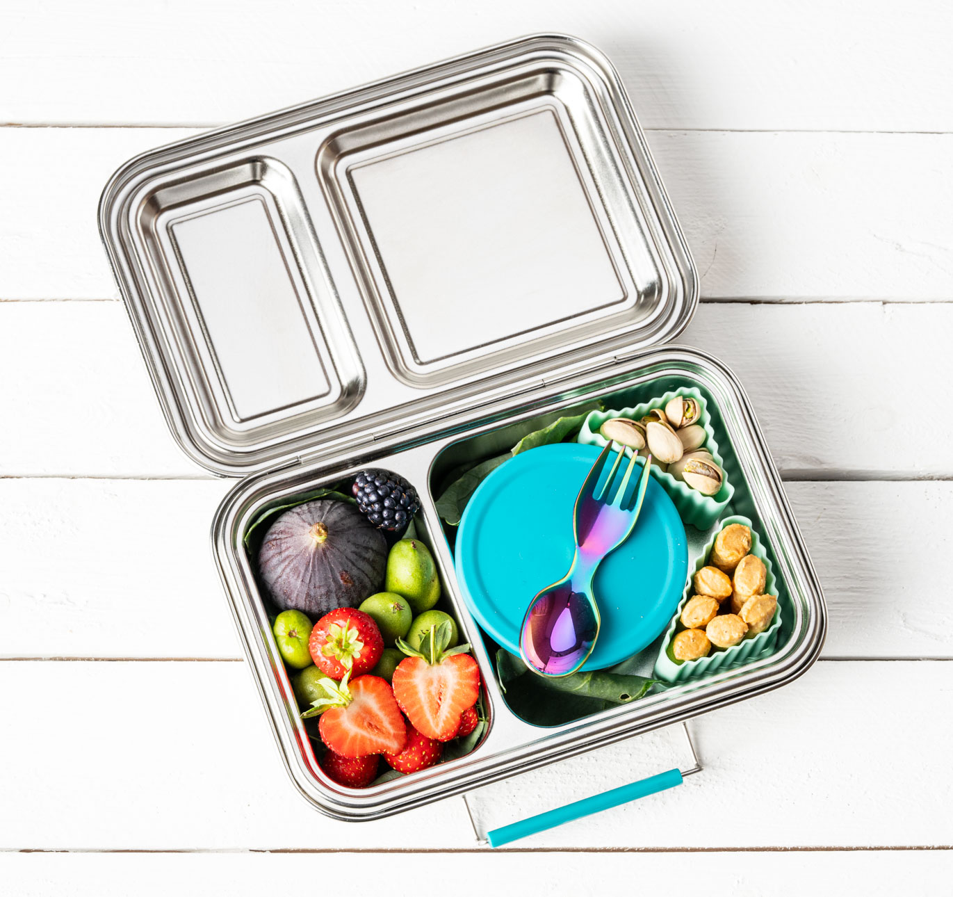 LEKKABOX Edelstahl Lunchbox mit Obst, Nüssen und Snackdosen, ergänzt durch einen Mini Göffel, der perfekt in die Brotdose passt und ideal für unterwegs ist.