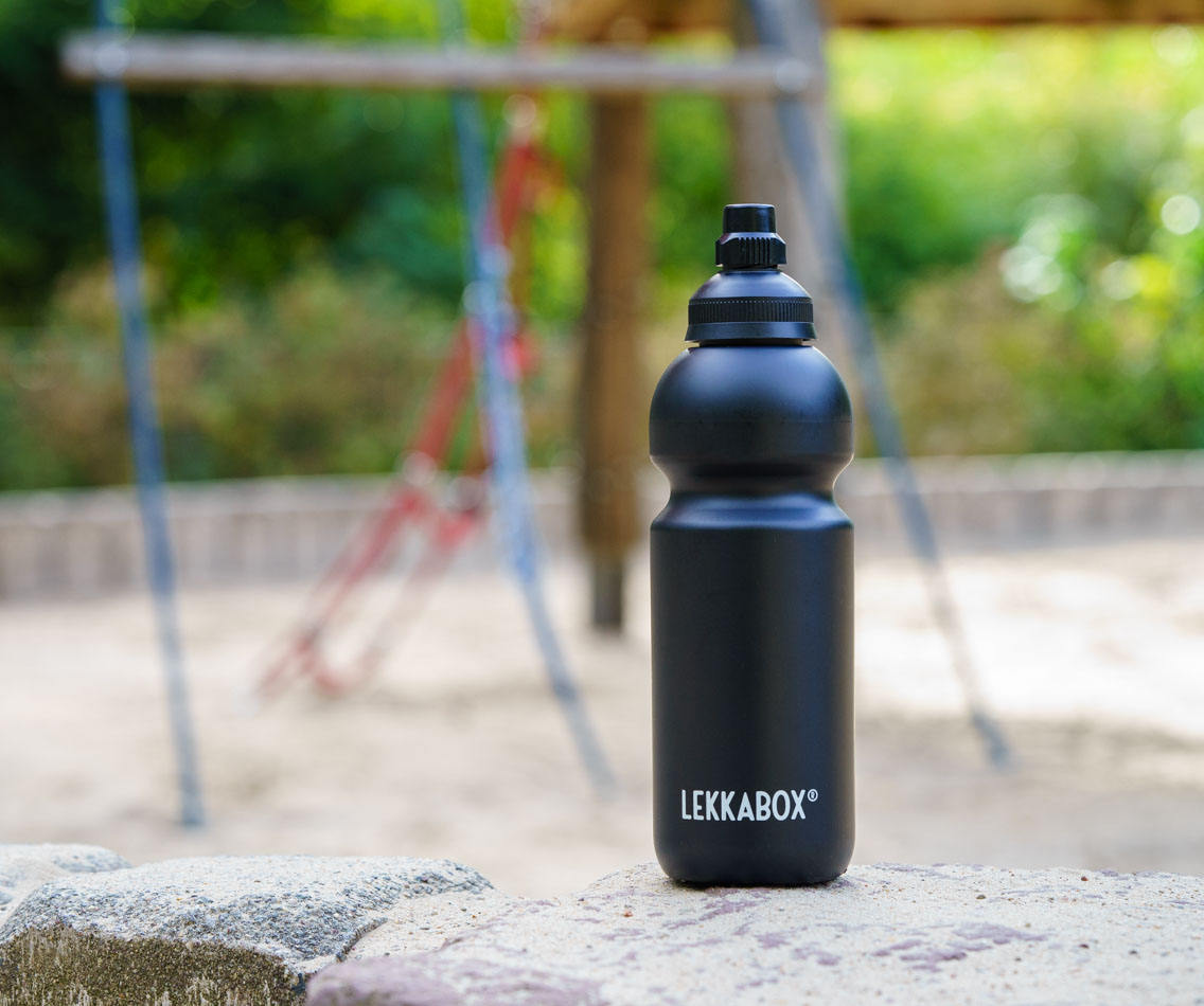 Schwarze LEKKABOX Bubble Trinkflasche für Kohlensäure auf einem Spielplatz